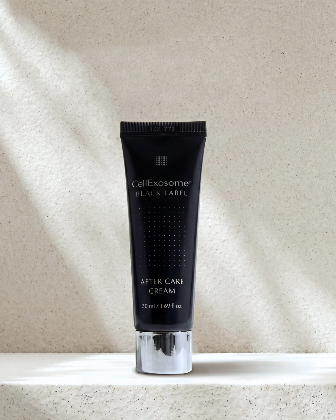 Black tube of CellExosome Black Label After Care Cream on a beige background