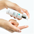 Hand holding Rejuran Intensive Pigment Corrector on a white background